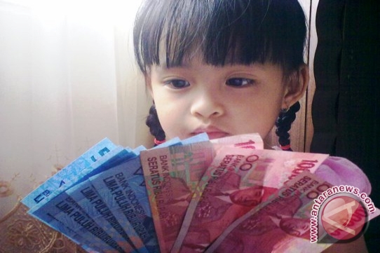 Anisa seorang bocah di Palembang sedang memegang uang rupiah kertas pecahan Rp50.000 dan Rp100.000. (Foto Antarasumsel.com/Yudi Abdullah/13) - 20130930nisa-rp1